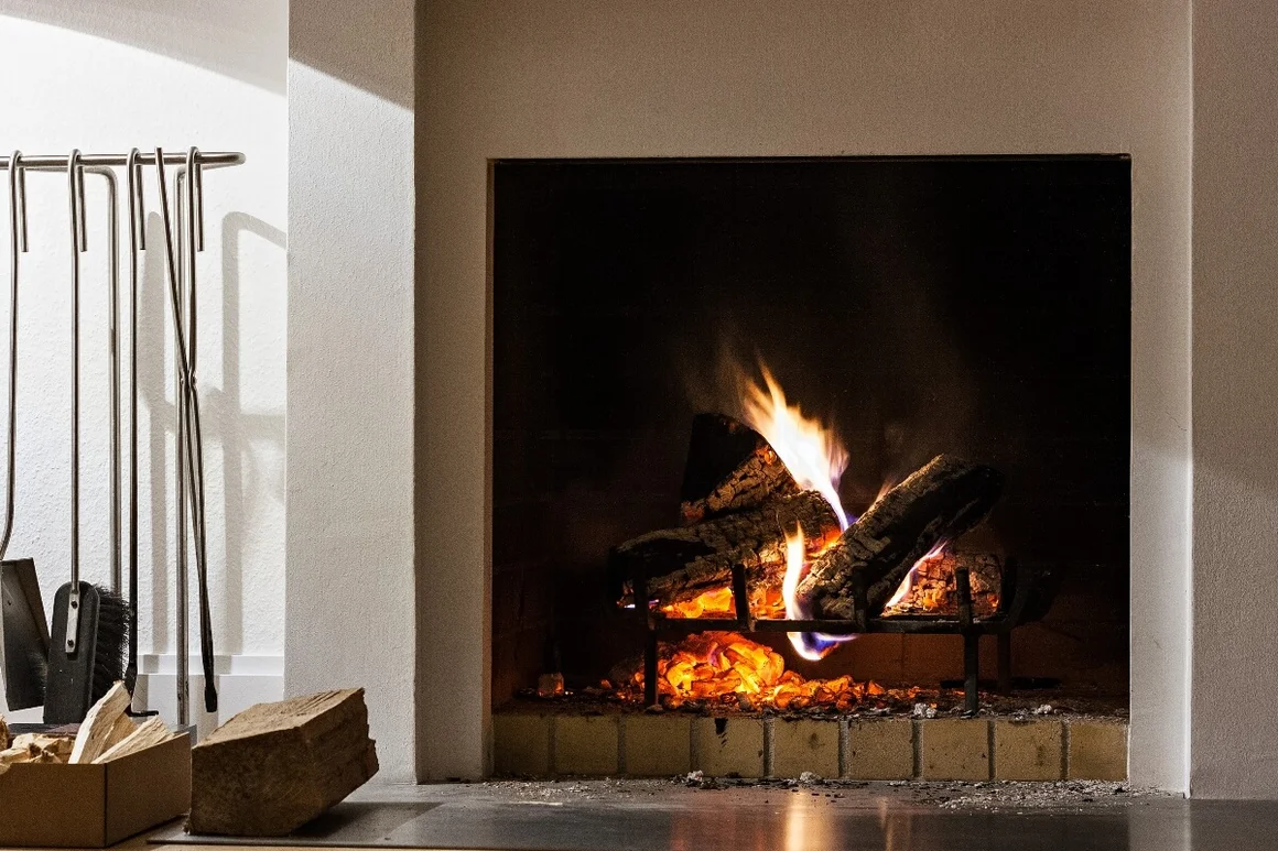 Brennendes Kaminfeuer mit Kaminbesteck